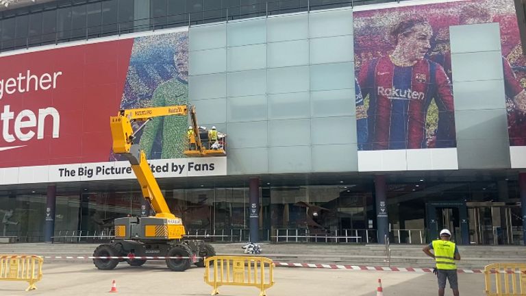Workers in Barcelona remove a huge image of their former player Lionel Messi from the side of the Nou Camp.